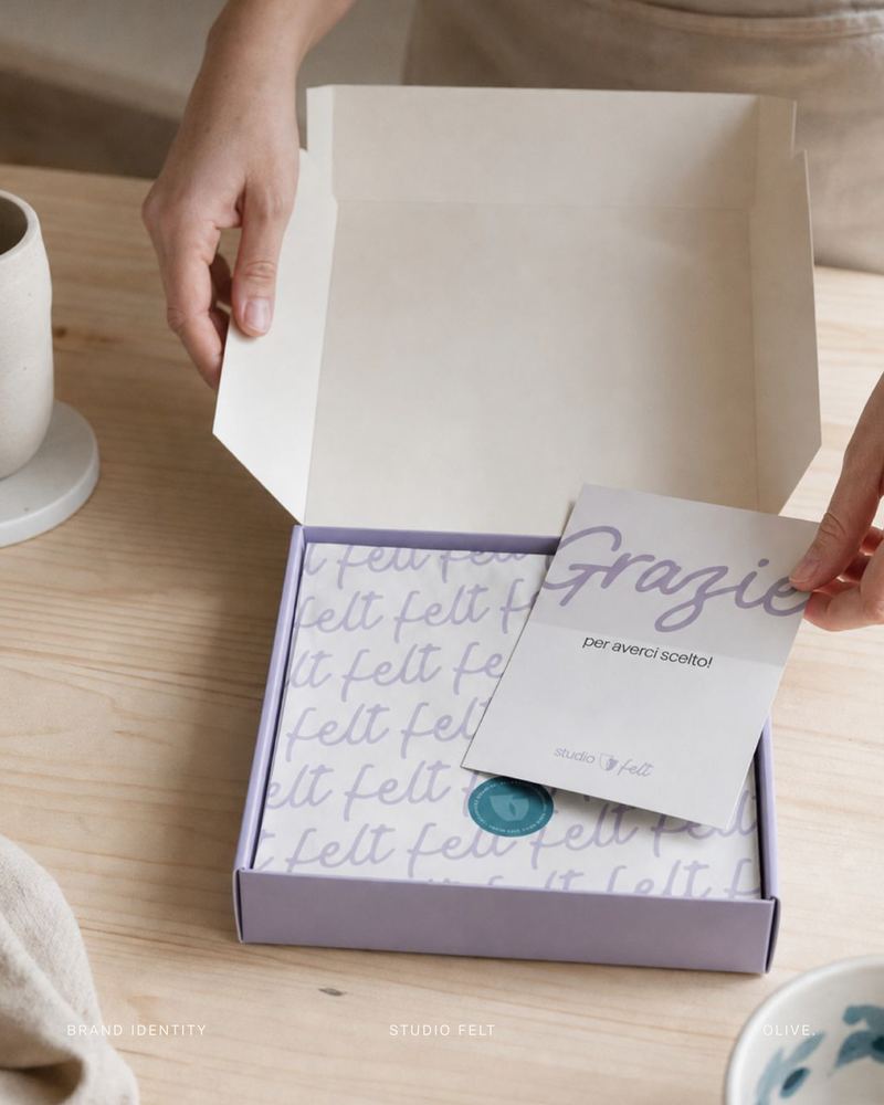 Scatola di Studio Felt aperta, con carta velina a motivo e biglietto di ringraziamento