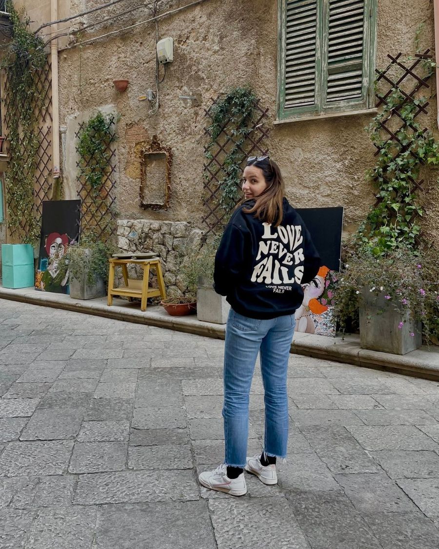 Olivia in un vicolo, con la felpa Love Never Fails